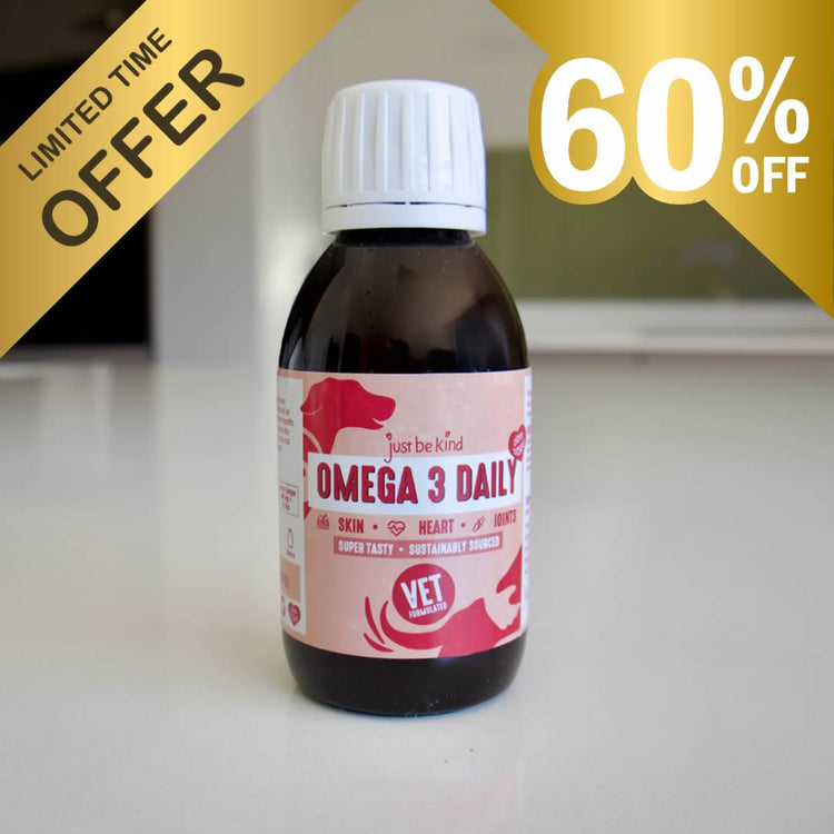 A bottle of Just Be Kind OMEGA 3 DAILY for pets, featuring a pink label and white cap, set against a blurred indoor background with promotional 'LIMITED TIME OFFER' and '60% OFF' text overlays.