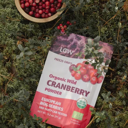 Package of Organic Wild Cranberry Powder on a natural background with cranberries.